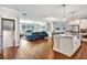Open floor plan connecting a modern kitchen with a sunlit living room, fireplace, and hardwood floors at 5293 Hearthstone St, Stone Mountain, GA 30083