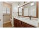 Bathroom with double sink vanity, dark wood cabinets, unique tile floor, and a window with shutters at 626 Cheatham Sw Dr, Marietta, GA 30064
