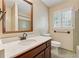 Bathroom with wooden vanity, mirror, and tiled shower, complemented by a window with shuttered blinds at 626 Cheatham Sw Dr, Marietta, GA 30064