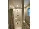 Updated bathroom featuring walk in shower with pebble tile and updated tile flooring at 710 Wind Song Trce, Woodstock, GA 30189