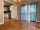 Bright dining area connected to the kitchen featuring hardwood floors and large windows with sheer curtains at 710 Wind Song Trce, Woodstock, GA 30189