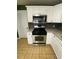 Well-lit kitchen has white cabinets, gray backsplash, and stainless steel range at 710 Wind Song Trce, Woodstock, GA 30189