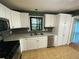 This kitchen offers stainless steel dishwasher and sink with white cabinets at 710 Wind Song Trce, Woodstock, GA 30189