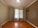 A cozy living room featuring hardwood floors, neutral paint, and a window with decorative curtains at 710 Wind Song Trce, Woodstock, GA 30189