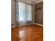 Living room featuring hardwood floors, natural light and large windows with decorative curtains at 710 Wind Song Trce, Woodstock, GA 30189