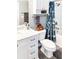 Bright bathroom features a white vanity, tile surround bathtub/shower, and toilet with a whimsical plush toy at 800 Peachtree Ne St # 1319, Atlanta, GA 30308