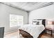 Bedroom featuring natural light, wood floors, large bed with decorative pillows, and exposed piping and ceiling at 800 Peachtree Ne St # 1319, Atlanta, GA 30308