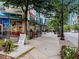 Sidewalk view of restaurant with outdoor seating and nearby businesses at 800 Peachtree Ne St # 1319, Atlanta, GA 30308