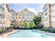 Exterior view of a community swimming pool surrounded by lounge chairs and apartment building at 800 Peachtree Ne St # 1319, Atlanta, GA 30308