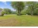 Expansive backyard features a large green lawn, mature trees, and a swimming pool at 256 Teresa Ln, Loganville, GA 30052