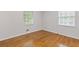 Bright bedroom featuring gleaming hardwood floors and natural light from two large windows at 256 Teresa Ln, Loganville, GA 30052