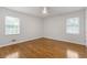 Spacious bedroom with hardwood floors, a ceiling fan and natural light from two large windows at 256 Teresa Ln, Loganville, GA 30052