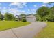 This ranch-style home features an attached garage, a long driveway, and verdant lawn at 256 Teresa Ln, Loganville, GA 30052