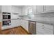 Updated kitchen boasts stainless appliances, white cabinetry, granite counters, and stylish subway tile backsplash at 256 Teresa Ln, Loganville, GA 30052