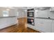 Modern kitchen featuring stainless steel appliances, white cabinets, granite countertops, and hardwood floors at 256 Teresa Ln, Loganville, GA 30052