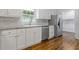 Updated kitchen featuring stainless steel appliances, granite countertops, and white cabinets at 256 Teresa Ln, Loganville, GA 30052
