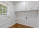 Bright laundry room with white cabinets and convenient access to the outdoors at 256 Teresa Ln, Loganville, GA 30052
