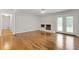Bright living room featuring hardwood floors, a brick fireplace, and access to the outdoors through double doors at 256 Teresa Ln, Loganville, GA 30052