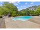 Outdoor pool with table and chairs sitting on a concrete patio surrounded by green landscape at 256 Teresa Ln, Loganville, GA 30052