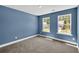 This bedroom offers natural light from two windows and soft, neutral carpeting at 8 Foothills Trl, Sharpsburg, GA 30277