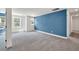 Spacious bedroom with plush carpeting, large windows, and a striking blue accent wall at 8 Foothills Trl, Sharpsburg, GA 30277