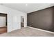 Bedroom with en suite bathroom and walk-in closet featuring carpeted floor and brown accent wall at 8 Foothills Trl, Sharpsburg, GA 30277