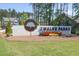 The community entrance sign showcases professional landscaping and a welcoming atmosphere at 8 Foothills Trl, Sharpsburg, GA 30277