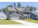 Side view of a gray two story home with an attached two car garage and driveway at 8 Foothills Trl, Sharpsburg, GA 30277