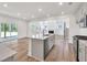 Open concept kitchen with stainless steel appliances, island, and adjacent living space with fireplace at 8 Foothills Trl, Sharpsburg, GA 30277