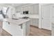 Close-up of kitchen island, showcasing white countertops, stainless steel sink and faucet, and light wood floors at 8 Foothills Trl, Sharpsburg, GA 30277