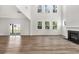 Bright, open living room with fireplace, large windows, and wood flooring at 8 Foothills Trl, Sharpsburg, GA 30277
