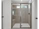 A tiled shower with a glass enclosure and a small window at 8 Foothills Trl, Sharpsburg, GA 30277
