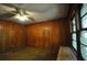 Bedroom features wood paneled walls, a ceiling fan, and natural light from the large window at 1305 Lenox Cir, Atlanta, GA 30306
