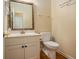 Cozy half-bathroom featuring a mirrored sink, toilet, and light fixtures at 1644 Beaver Creek Ln, Snellville, GA 30078