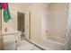 Clean and efficient bathroom with white tiled shower/tub, toilet, and sink, illuminated by overhead lighting at 1644 Beaver Creek Ln, Snellville, GA 30078