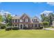Charming two-story brick home with lush lawn, manicured landscaping, and a symmetrical facade under a bright, blue sky at 1644 Beaver Creek Ln, Snellville, GA 30078