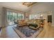 Open-concept living room features a large sectional sofa, big windows, and hardwood floors at 270 Alcovy Reserve Way, Covington, GA 30014
