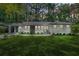 Beautifully landscaped front yard with green grass, green front door and a covered car port, providing great curb appeal at 3337 Toney Dr, Decatur, GA 30032