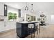 Modern kitchen with an island, bar stools, stainless steel appliances, and open dining area view at 3337 Toney Dr, Decatur, GA 30032