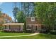Charming brick home featuring manicured lawn, mature trees, and inviting front entrance at 461 Village Green Sw Ct, Lilburn, GA 30047