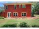 Spacious backyard featuring a well-maintained lawn, brick facade, and access doors at 781 Templeton Dr, Loganville, GA 30052