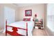 Charming bedroom featuring a red bed frame, white bedding, and a window with blinds for natural light at 781 Templeton Dr, Loganville, GA 30052