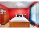 Bright red bedroom with wood furniture, white bedding, and natural light at 781 Templeton Dr, Loganville, GA 30052