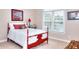 Bright bedroom featuring a red bed frame, white bedding, and a window with blinds for natural light at 781 Templeton Dr, Loganville, GA 30052