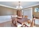 Traditional dining room featuring wood floors, wainscoting, and a decorative chandelier at 781 Templeton Dr, Loganville, GA 30052