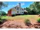 Back of the house featuring a covered porch, a large yard, and partial brick, blending style and outdoor space at 781 Templeton Dr, Loganville, GA 30052