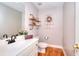 Traditional powder room featuring hardwood floors, decorative shelves, and a wreath-adorned window at 781 Templeton Dr, Loganville, GA 30052