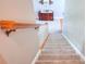Carpeted staircase with a wooden handrail, creating a seamless transition between floors at 781 Templeton Dr, Loganville, GA 30052