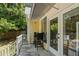 Back porch with an outdoor dining area, surrounded by trees and greenery, with stairs leading to the yard at 161 N Barton St, Norcross, GA 30071