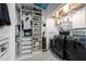 Walk-in closet with black washer and dryer, shelves for shoes, and multiple racks for clothing at 161 N Barton St, Norcross, GA 30071